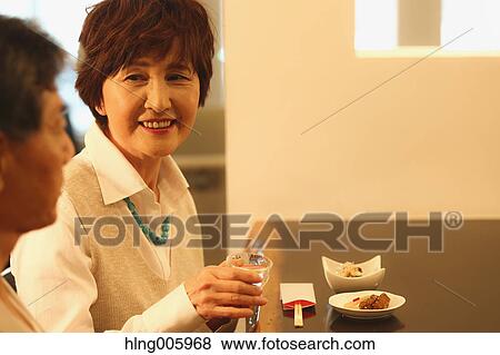 Fashionable Japanese senior couple having a good time at the restaurant View Large Photo Image Stock Photo - Fashionable Japanese senior couple having a good time at the restaurant. Fotosearch