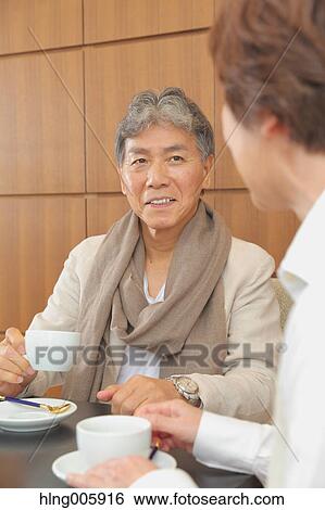 Fashionable Japanese senior couple enjoying a cup of coffee View Large Photo Image Stock Photograph - Fashionable Japanese senior couple enjoying a cup of coffee. Fotosearch