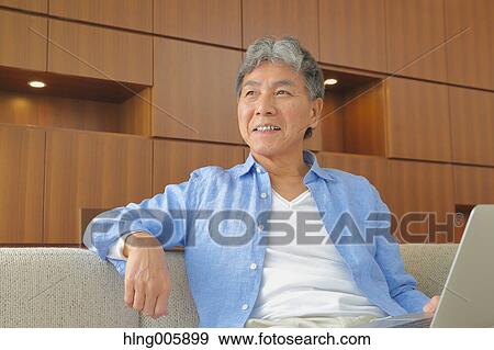 Stock Photo - Fashionable Japanese senior man working. Fotosearch