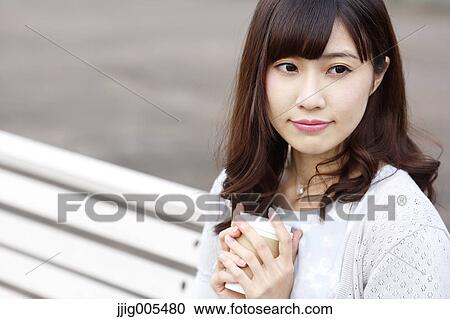 Fashionable Japanese woman with coffee sitting on a bench by the river, Tokyo, Japan View Large Photo Image Stock Image - Fashionable Japanese woman with coffee sitting on a bench by the river, Tokyo, Japan. Fotosearch
