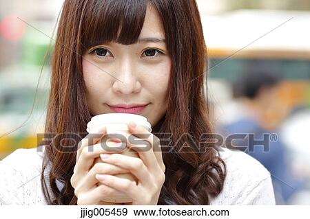 Stock Photo - Fashionable Japanese woman with coffee in luxury Tokyo area, Tokyo, Japan. Fotosearch