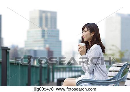 Fashionable Japanese woman with coffee sitting on a bench by the river, Tokyo, Japan View Large Photo Image Stock Photo - Fashionable Japanese woman with coffee sitting on a bench by the river, Tokyo, Japan. Fotosearch