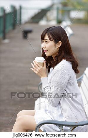 Fashionable Japanese woman with coffee sitting on a bench by the river, Tokyo, Japan View Large Photo Image Stock Photograph - Fashionable Japanese woman with coffee sitting on a bench by the river, Tokyo, Japan. Fotosearch