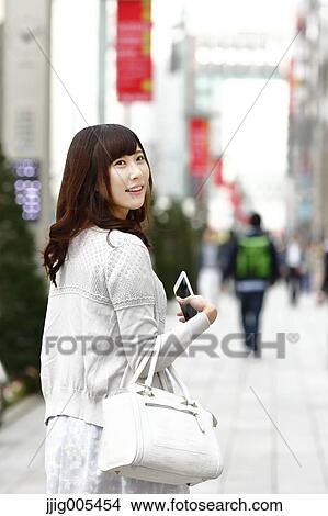 Fashionable Japanese woman with smartphone in luxury Tokyo area, Tokyo, Japan View Large Photo Image Picture - Fashionable Japanese woman with smartphone in luxury Tokyo area, Tokyo, Japan. Fotosearch
