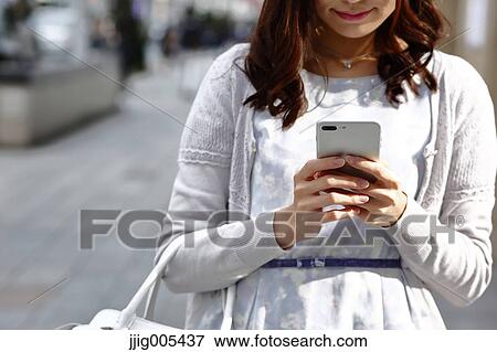 Fashionable Japanese woman with smartphone in luxury Tokyo area, Tokyo, Japan View Large Photo Image Stock Photo - Fashionable Japanese woman with smartphone in luxury Tokyo area, Tokyo, Japan. Fotosearch