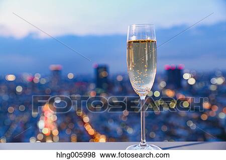 Stock Photo - Glass of champagne in front of Tokyo cityscape. Fotosearch