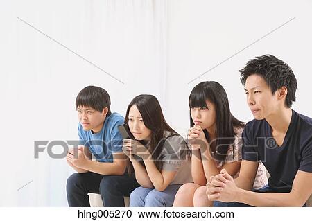 Stock Image - Group of Japanese supporters in the living room. Fotosearch