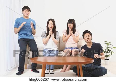 Stock Photo - Group of Japanese supporters in the living room. Fotosearch