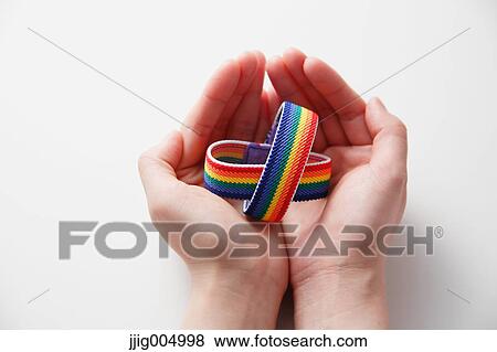Hands holding rainbow wristbands View Large Photo Image Stock Photo - Hands holding rainbow wristbands. Fotosearch