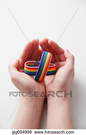 Hands holding rainbow wristbands View Large Photo Image Stock Photo - Hands holding rainbow wristbands. Fotosearch