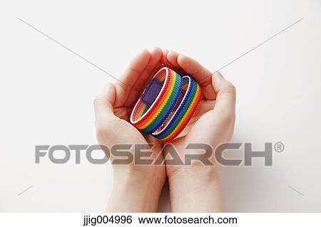 Hands holding rainbow wristbands View Large Photo Image Stock Photograph - Hands holding rainbow wristbands. Fotosearch
