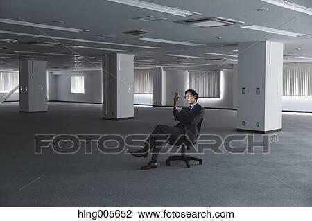 Stock Image - Japanese businessman in empty office. Fotosearch