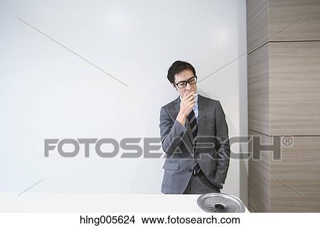 Picture - Japanese businessman in smoking room. Fotosearch