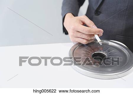 Stock Image - Japanese businessman in smoking room. Fotosearch