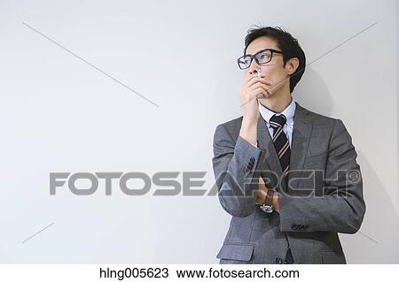 Stock Image - Japanese businessman in smoking room. Fotosearch
