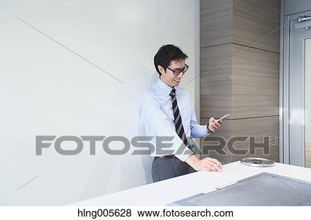 Stock Photo - Japanese businessman in smoking room. Fotosearch
