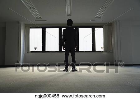 Japanese businessman looking out of the window in empty office View Large Photo Image Stock Photo - Japanese businessman looking out of the window in empty office. Fotosearch