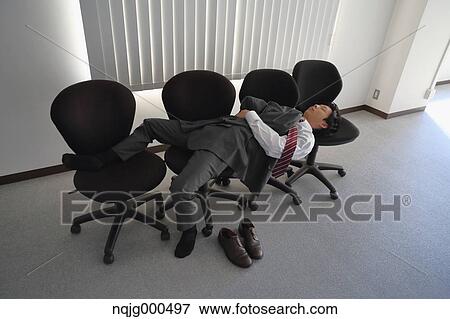 Japanese businessman sleeping on chairs View Large Photo Image Stock Photo - Japanese businessman sleeping on chairs. Fotosearch