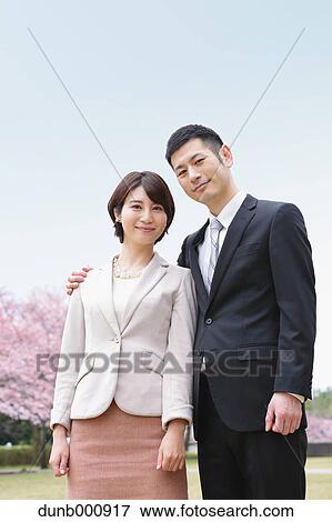 Japanese couple with cherry blossoms in a city park View Large Photo Image Stock Photo - Japanese couple with cherry blossoms in a city park. Fotosearch