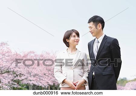 Japanese couple with cherry blossoms in a city park View Large Photo Image Stock Photograph - Japanese couple with cherry blossoms in a city park. Fotosearch