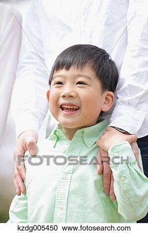 Stock Image - Japanese father and son in a city park. Fotosearch