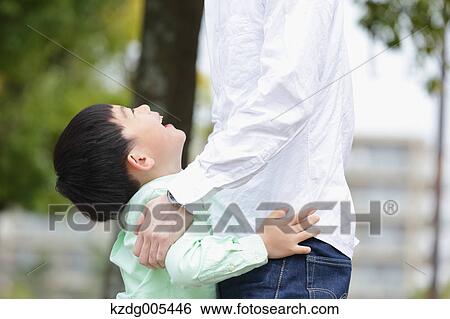 Stock Photograph - Japanese father and son in a city park. Fotosearch