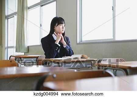 Picture - Japanese high-school student in empty classroom. Fotosearch