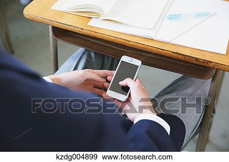 Japanese high-school student using smartphone during a lesson View Large Photo Image Stock Photo - Japanese high-school student using smartphone during a lesson. Fotosearch