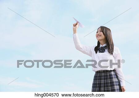 Stock Image - Japanese high-school student with paper plane. Fotosearch