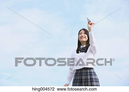 Stock Image - Japanese high-school student with paper plane. Fotosearch