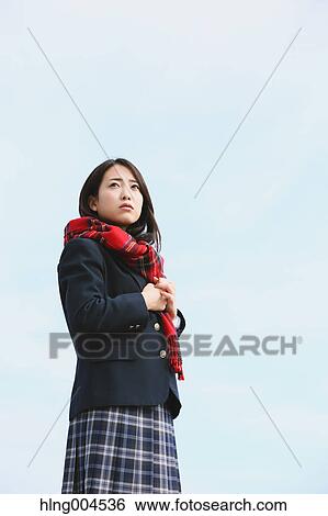 Stock Photograph - Japanese high-school student with scarf against blue sky. Fotosearch