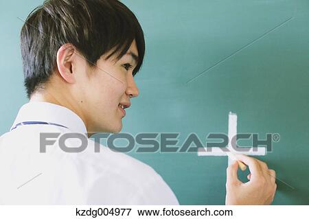 Stock Photo - Japanese high-school student writing on classroom blackboard. Fotosearch