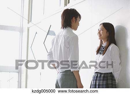 Stock Image - Japanese high-school students in a romantic moment in the school corridor. Fotosearch