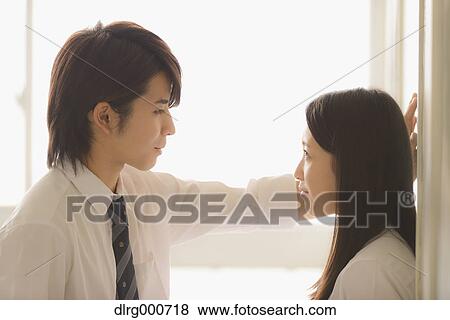 Stock Photo - Japanese high-school students in a romantic moment in the school corridor. Fotosearch