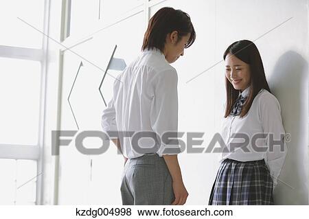 Stock Photo - Japanese high-school students in a romantic moment in the school corridor. Fotosearch