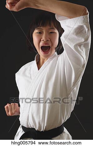 Picture - Japanese kid in karate uniform on black background. Fotosearch