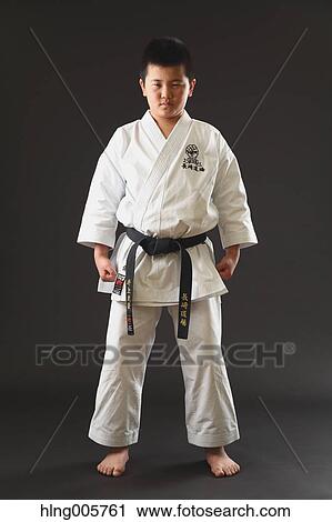 Stock Image - Japanese kid in karate uniform on black background. Fotosearch
