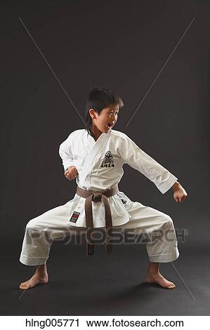 Stock Image - Japanese kid in karate uniform on black background. Fotosearch