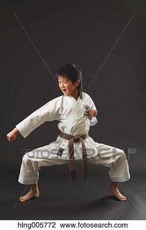 Stock Image - Japanese kid in karate uniform on black background. Fotosearch