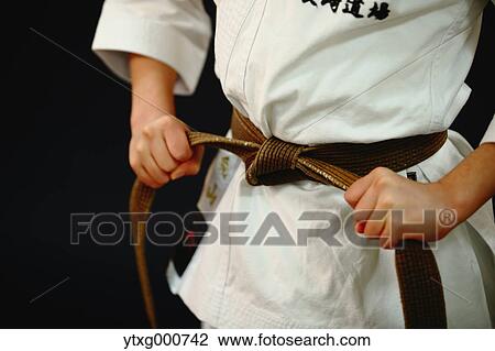 Stock Image - Japanese kid in karate uniform on black background. Fotosearch
