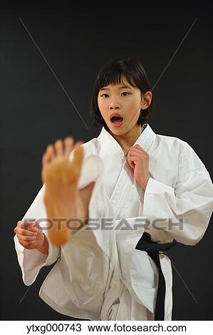 Stock Image - Japanese kid in karate uniform on black background. Fotosearch