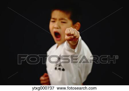 Stock Photo - Japanese kid in karate uniform on black background. Fotosearch