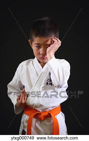 Stock Photo - Japanese kid in karate uniform on black background. Fotosearch