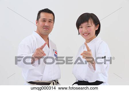 Picture - Japanese kid in karate uniform training with teacher on white background. Fotosearch