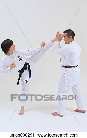 Stock Image - Japanese kid in karate uniform training with teacher on white background. Fotosearch