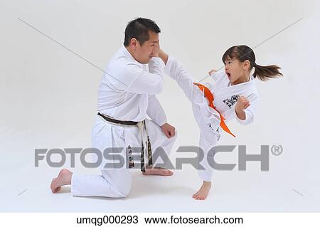 Stock Image - Japanese kid in karate uniform training with teacher on white background. Fotosearch