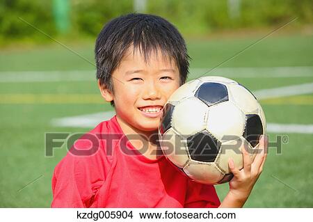 Picture - Japanese kid playing soccer. Fotosearch