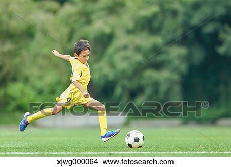 Picture - Japanese kid playing soccer. Fotosearch