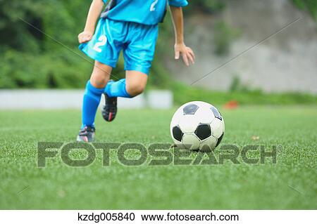 Stock Image - Japanese kid playing soccer. Fotosearch