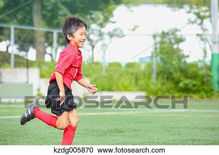 Stock Image - Japanese kid playing soccer. Fotosearch